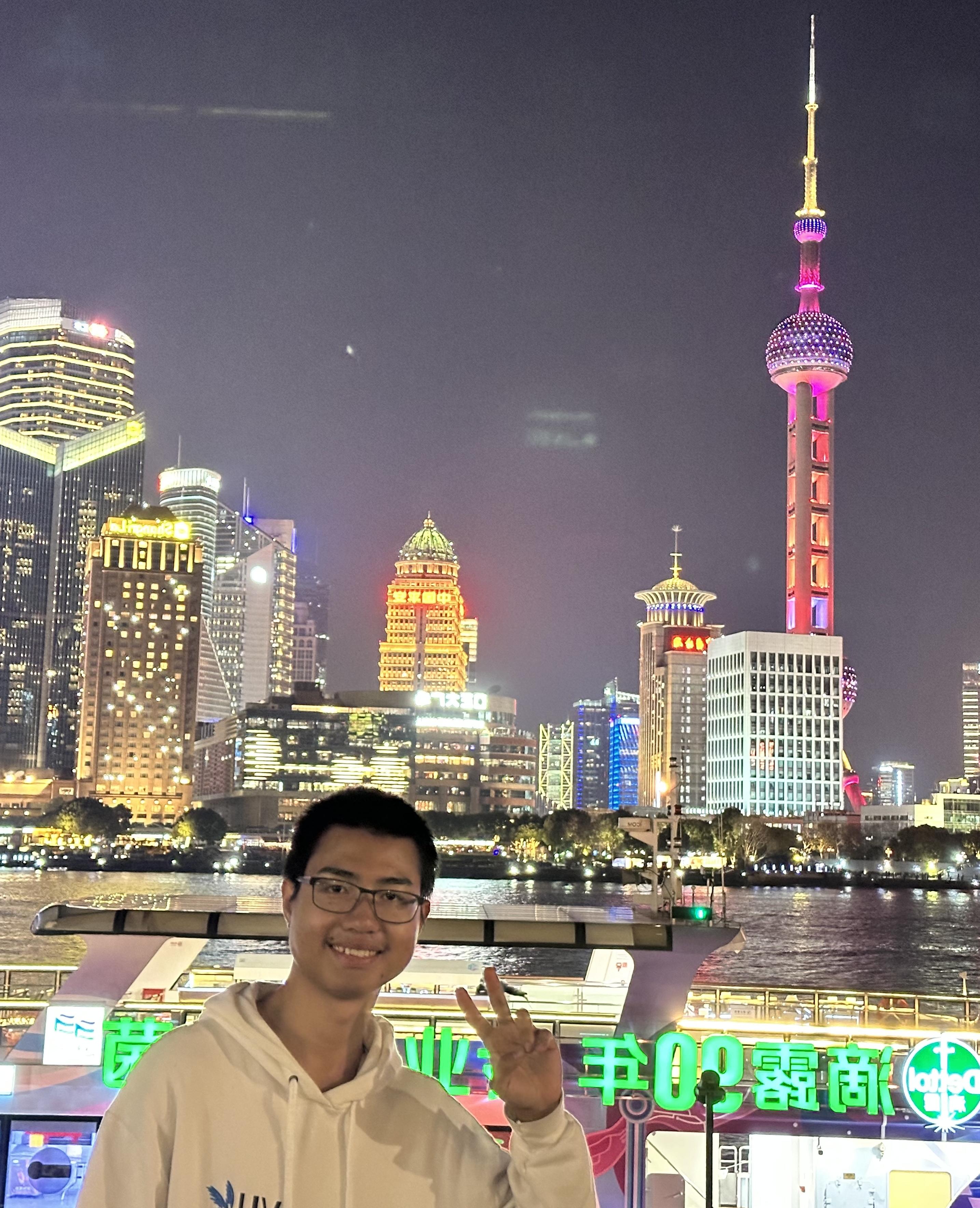 Student in front of urban skyline at night.